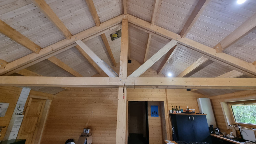 Charpente apparente intérieure dans un chalet en bois habitable de 100m2